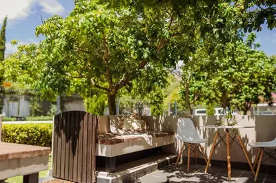 a fence with a table and chairs and a tree at Apartment in central Stellenbosch in Stellenbosch