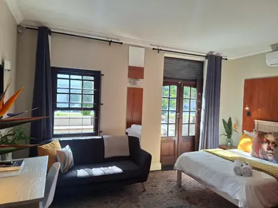 a living room with a couch and a bed at Apartment in central Stellenbosch in Stellenbosch