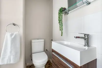 a bathroom with a white toilet and a sink at Witsand 102 in Bloubergstrand
