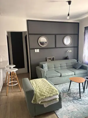a living room with a couch and a table at Serenity Hideaway in Cape Town