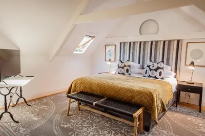 a bedroom with a large bed and a desk at Bonne Esperance Villa in Stellenbosch