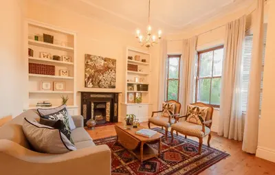 a living room with a couch and chairs and a fireplace at Bonne Esperance Villa in Stellenbosch