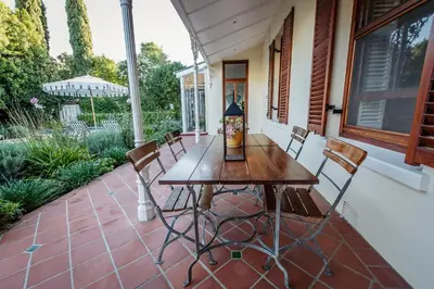a wooden table and chairs on a patio at Bonne Esperance Villa in Stellenbosch