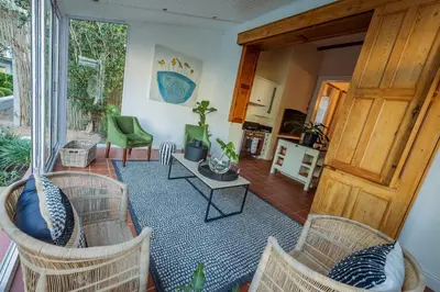 a living room with wicker chairs and a table at Bonne Esperance Villa in Stellenbosch