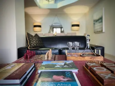 a table with books and wine glasses on top of it at Calais Guest House in Franschhoek