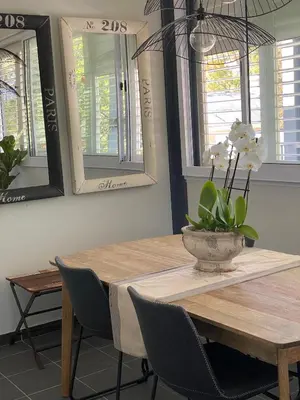 a dining room table with a vase of flowers on it at The Oak Suite - 7 on Murray Historic Stellenbosch in Stellenbosch