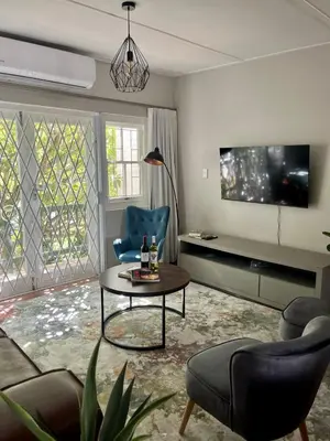 a living room with a table and chairs and a tv at Akker in Stellenbosch