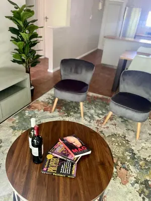 a coffee table with two chairs and a bottle of wine at Akker in Stellenbosch