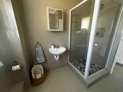 a bathroom with a shower and a sink at Modern 2 bedroom apartment close to shops & beach in Gordonʼs Bay