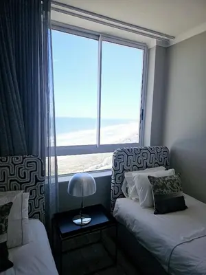 a bedroom with two beds and a large window at Portico 1103 in Cape Town