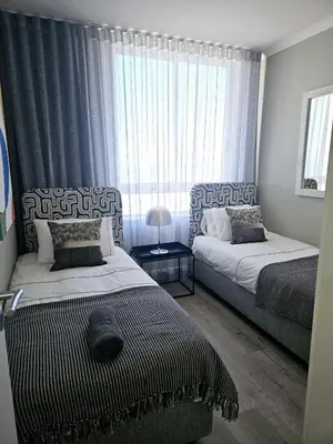 a bedroom with two beds and a window at Portico 1103 in Cape Town