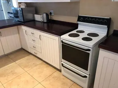 a kitchen with a stove and a counter top at House in Hermanus Voëlklip in Hermanus
