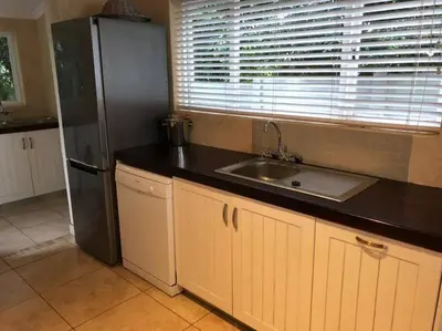 a kitchen with a black refrigerator and a sink at House in Hermanus Voëlklip in Hermanus