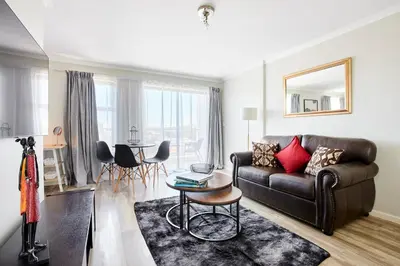 a living room with a couch and a table at The Rondebosch Views in Cape Town