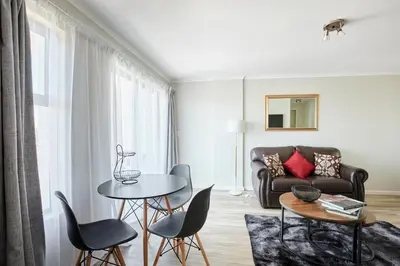 a living room with a couch and a table and chairs at The Rondebosch Views in Cape Town