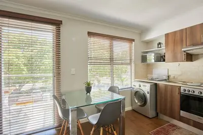 a kitchen with a table and chairs in a room at The Rondebosch Easy Living in Cape Town