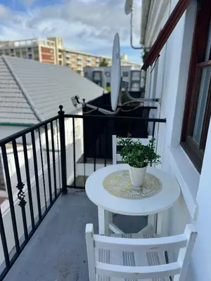 a table on a balcony with a plant on it at Affordable Guest house in Mwobray in Cape Town