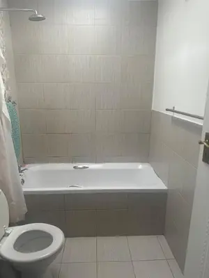 a bathroom with a white tub and a toilet at Affordable Guest house in Mwobray in Cape Town