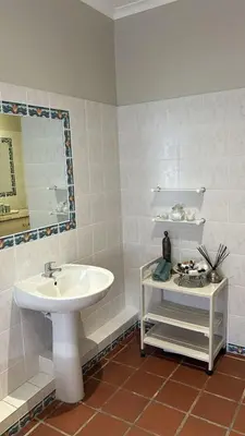 a bathroom with a sink and a mirror at House Simon in Somerset West