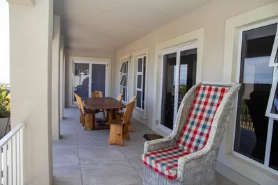a porch with chairs and a table on a balcony at House Simon in Somerset West