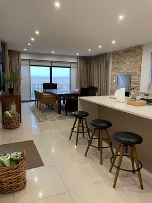 a kitchen and living room with a table and chairs at 29nTanglewood cr, Sunset Links residential Estate in Cape Town