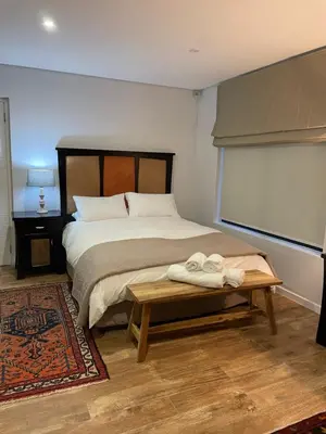 a bedroom with a bed and a table with towels on it at 29nTanglewood cr, Sunset Links residential Estate in Cape Town