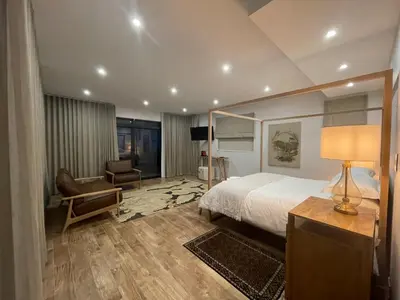 a hotel room with a bed and a chair at 29nTanglewood cr, Sunset Links residential Estate in Cape Town