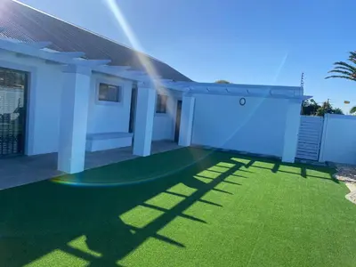 a house with a green lawn in front of it at 32 On Gill Road Self Catering in Cape Town