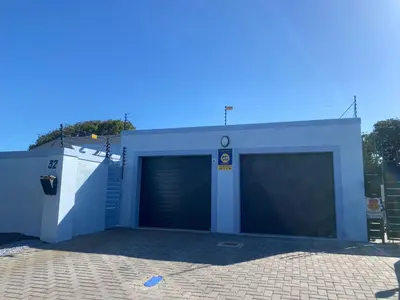 a garage with two garage doors and a building at 32 On Gill Road Self Catering in Cape Town
