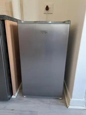 a silver refrigerator sitting in a corner of a room at The Muscadel - Paarl - Self Catering Apartment in Paarl