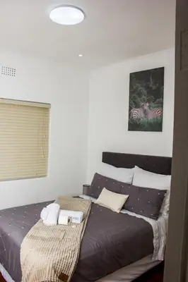 a bedroom with a bed and a picture of a zebra at Botha Villa Lodge Goodwood in Cape Town