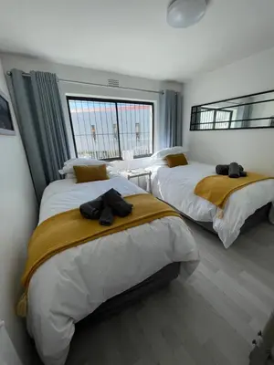 a bedroom with two beds and a large window at Blouberg Sea View in Bloubergstrand