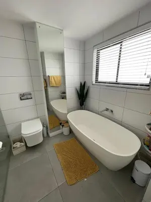 a bathroom with a tub and a toilet and a sink at Blouberg Sea View in Bloubergstrand