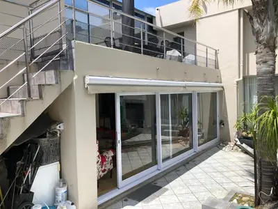a house with sliding glass doors and a balcony at Dusk 2 Dawn Self Catering Guest House in Cape Town