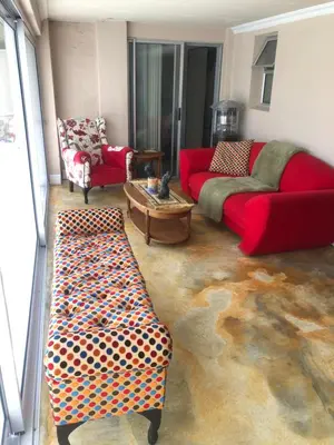 a living room with a red couch and a table at Dusk 2 Dawn Self Catering Guest House in Cape Town