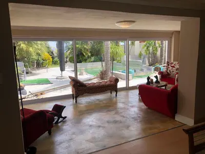 a living room with a large sliding glass door at Dusk 2 Dawn Self Catering Guest House in Cape Town