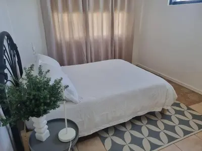 a bedroom with a bed and a table with a plant at Lanaria 9, Betty's Bay in Clareport
