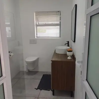 a white bathroom with a sink and a toilet at Lanaria 9, Betty's Bay in Clareport