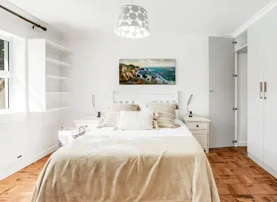 a white bedroom with a bed and a chandelier at Kiefern Haus Main House in Cape Town