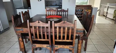 a wooden table with chairs and a bowl on it at Picollo Bocca Villa Kleinmond in Kleinmond