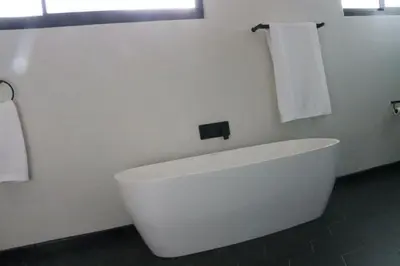 a white bath tub in a bathroom with towels at Villa Des Roses in Paarl