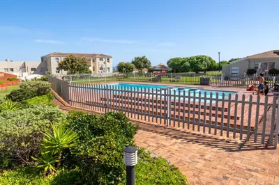 a fence around a swimming pool in a yard at House 12 Beach Club in Hermanus