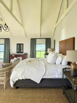 a bedroom with a large bed with white sheets at Moya's Vineyard in Mosselrivier