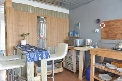a kitchen with a table and chairs in a room at Seaview on 2822 - Romantic Ocean Studio in Bettyʼs Bay