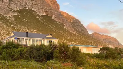 a house in front of a mountain at Seaview on 2822 - Romantic Ocean Studio in Bettyʼs Bay