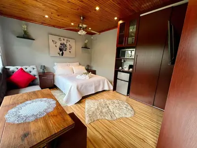 a bedroom with a bed and a living room at SharronDeez in Cape Town