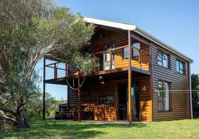 a large wooden house with a tree at Flock-Inn in Fisherhaven