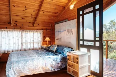 a bedroom with a bed and a large window at Flock-Inn in Fisherhaven