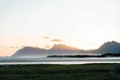 a sunset over a body of water with mountains in the background at Flock-Inn in Fisherhaven