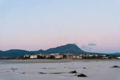 a beach with houses and mountains in the distance at Flock-Inn in Fisherhaven